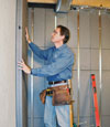Insulated basement wall panels being placed against a concrete foundation wall in Queensbury