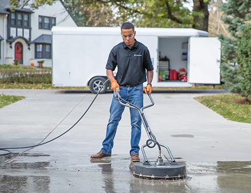 One of our experts sealing a concrete driveway
