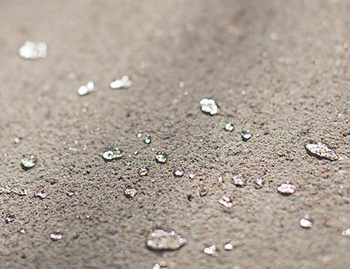 Close-up of water and other liquids on a concrete surface
