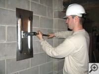 Attempting to straighten a bowed foundation wall by straightening a wall anchor system in a Latham home.