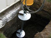 Installing a helical pier system in the earth around a foundation in Saratoga Springs