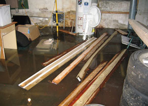 A severely flooding basement in Latham, with lumber and personal items floating in a foot of water