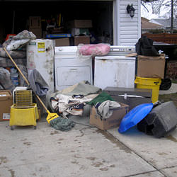 Soaked, wet personal items sitting in a driveway, including a washer and dryer in Clifton Park.